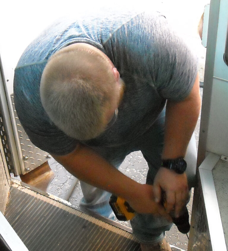 Employee installing bus steps