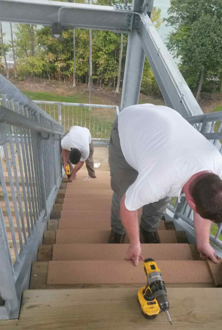 Employees installing step covers at metroparks