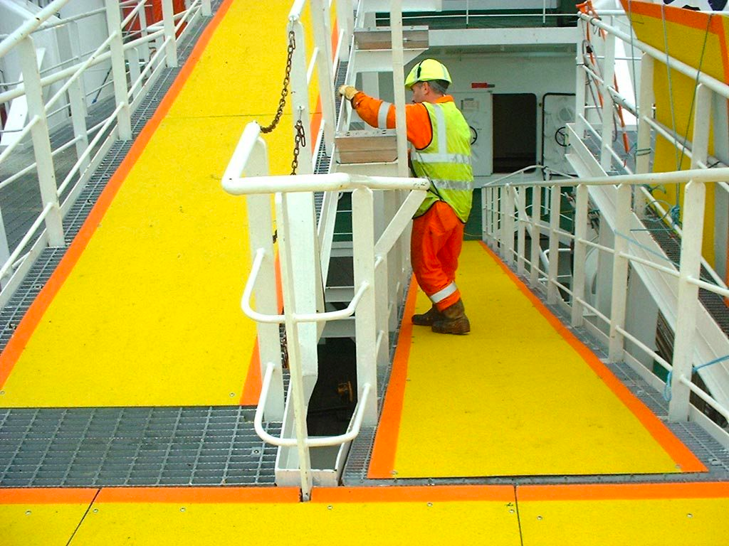 Multiple two-tone, non-skid walkway covers in yellow and orange cover grating in a marine application