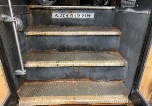 School Bus Steps With Worn Rubber Treads and Corroded Metal Substrate