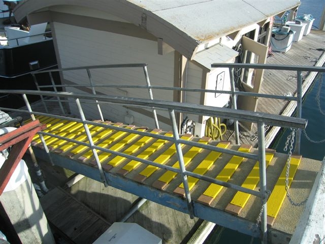 yellow anti-slip Step covers on wood boards on concrete walkway