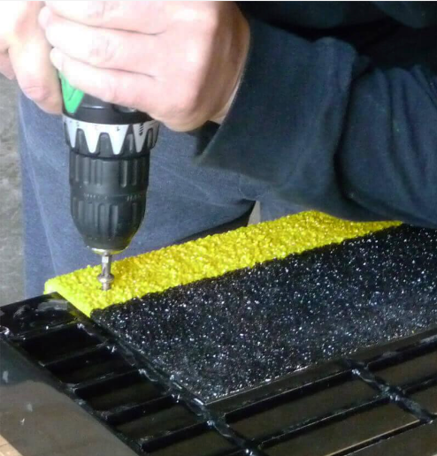 Anti-slip stair tread being installed by a professional with a drill